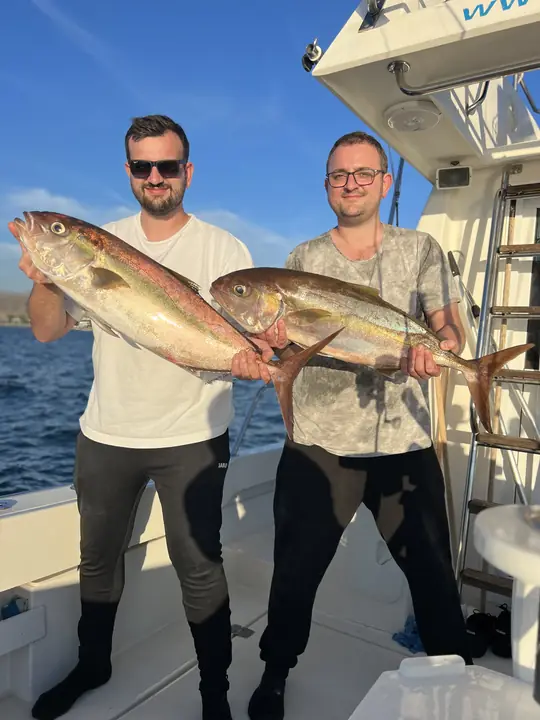 Två fiskare som håller amberjacks
