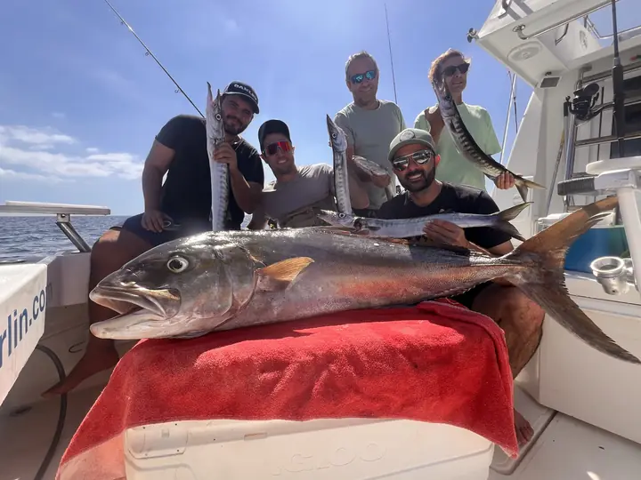 Grupp med en stor amberjack på däck