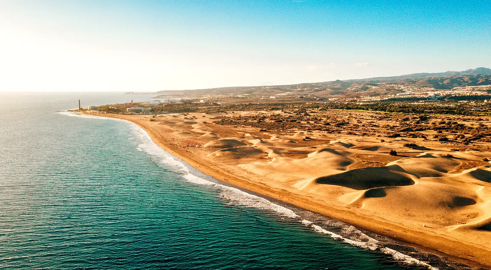 Flygbild över Maspalomas sanddyner och strand med fyren och Atlanten